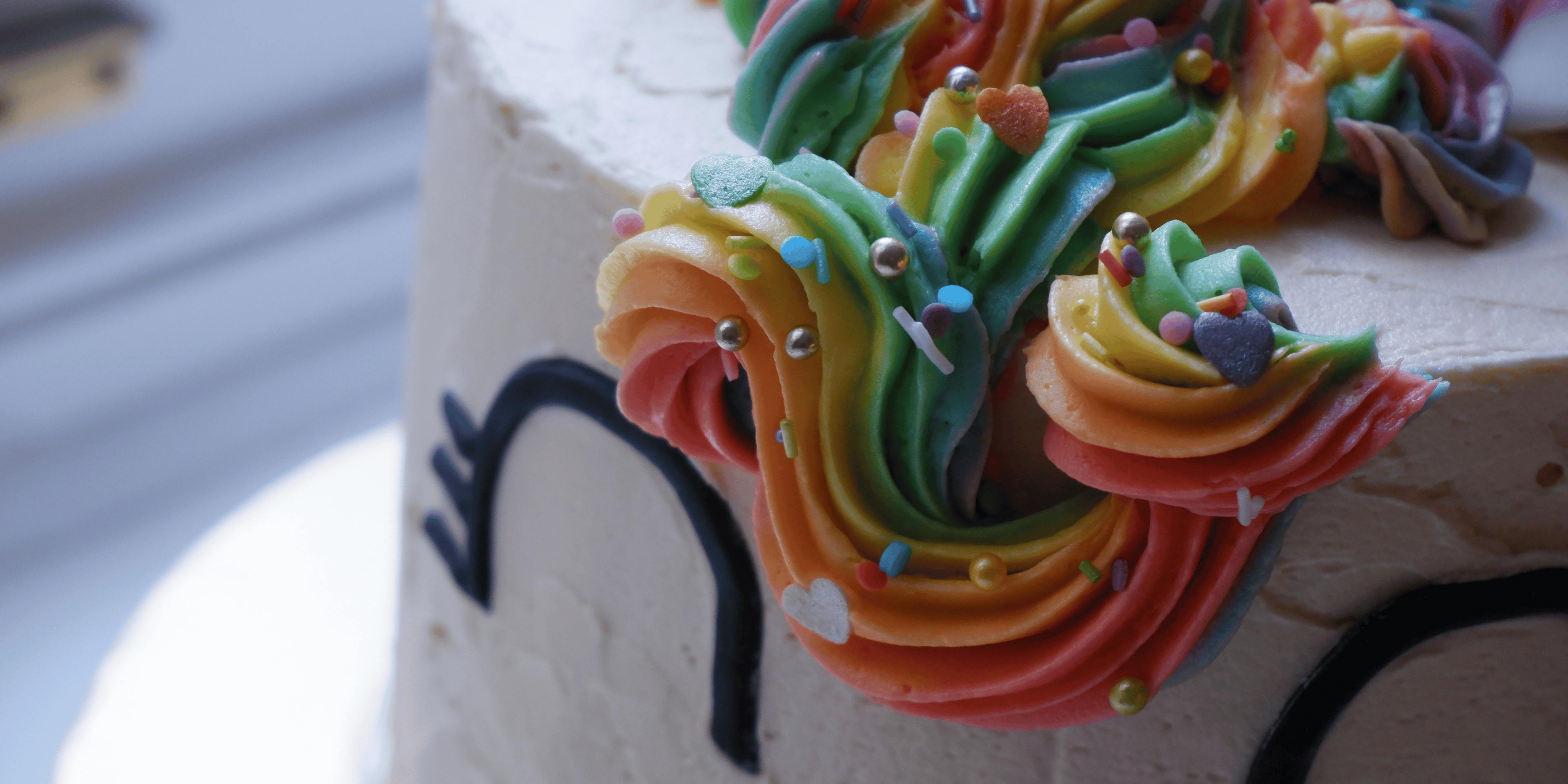 Close up of a unicorn cake with the mane colourful with rainbow colours.