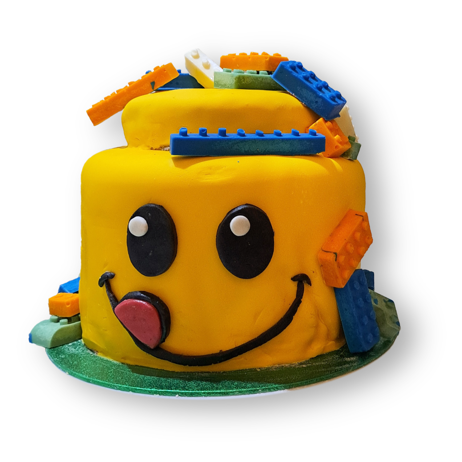 It is a cake with the shape of a lego head. The head is sticking its tongue out and it has chocolate legos all over it.