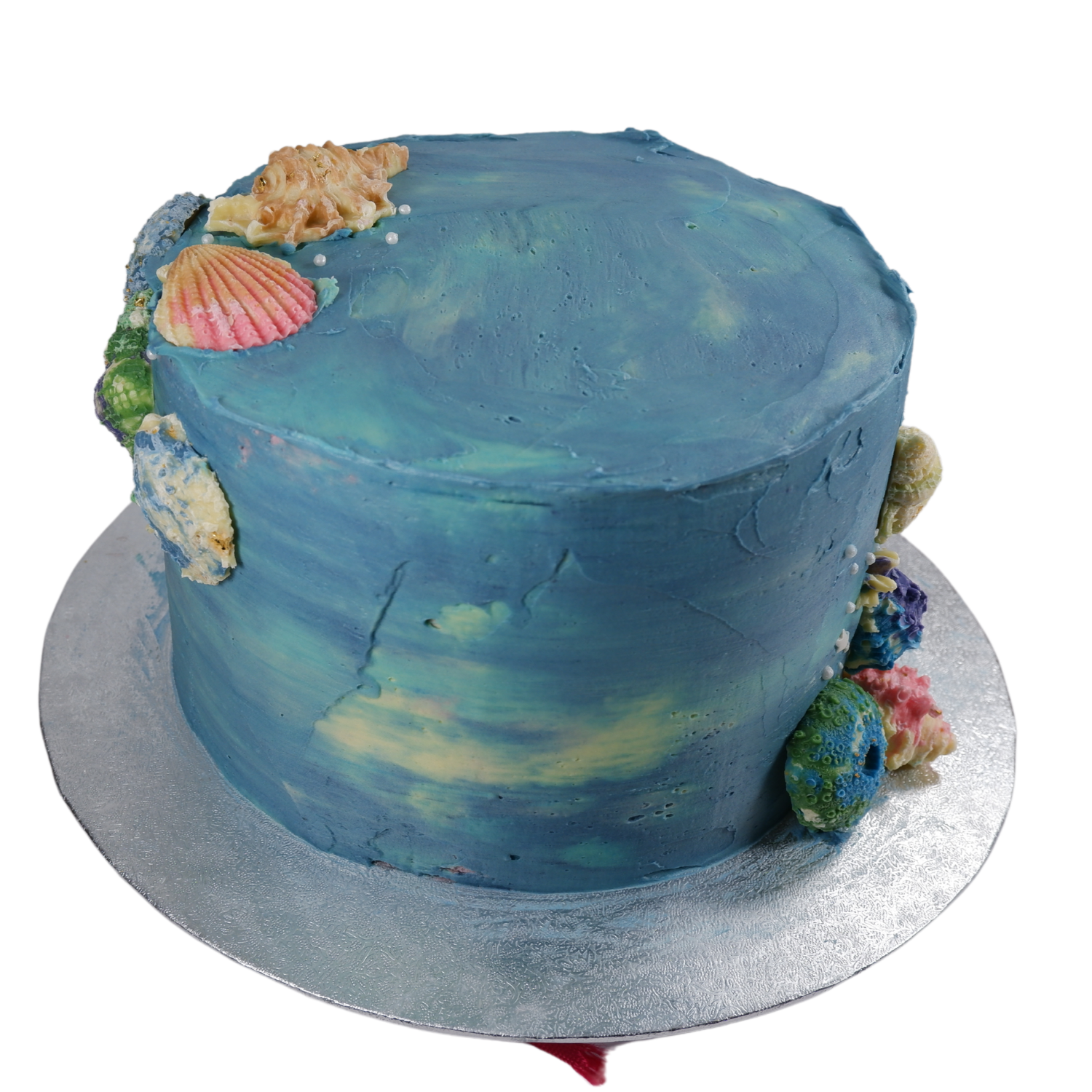 Different shade of blue cake with colourful chocolate shells.